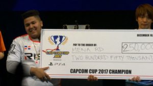 Saul "MenaRD" Mena, de 18 años, posa con el cheque por 250 mil dólares que ganó en la Capcom Cup 2017.